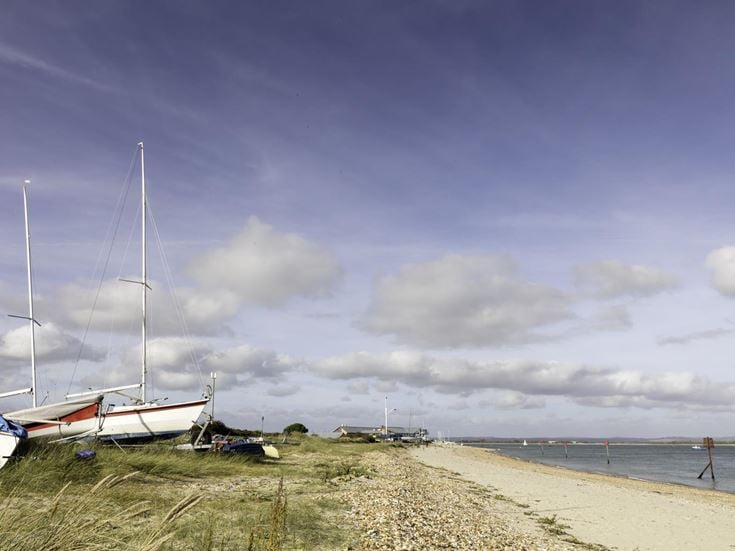 Sailing boats along the shoreline on Hayling Island, near Portsmouth.