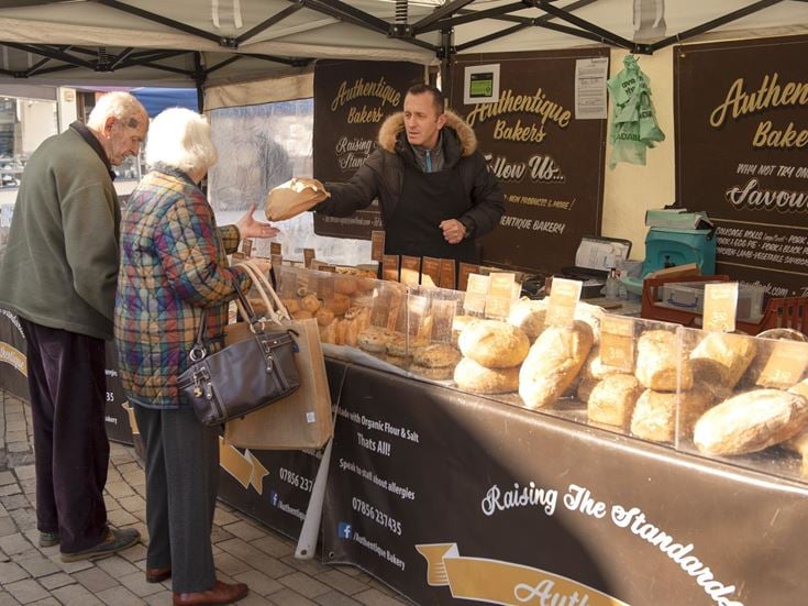 Two retirees buying bread at a local market in Romsey