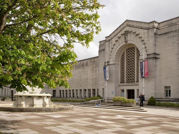 A fountain and tree outside the historic Southampton City Art Gallery building.