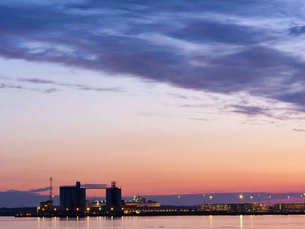 A view of Southampton from the water, with a purple city port skyline at sunset.