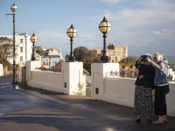 Two retired ladies taking photos in the streets of Broadstairs, Kent.