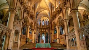 Inside Canterbury Cathedral, with an altar and red carpet.