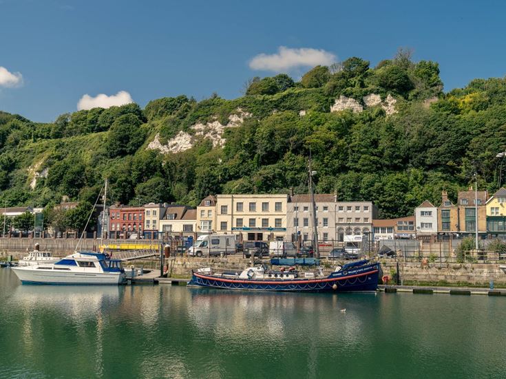 Boats in front of buildings and cliffs in Dover, Kent.