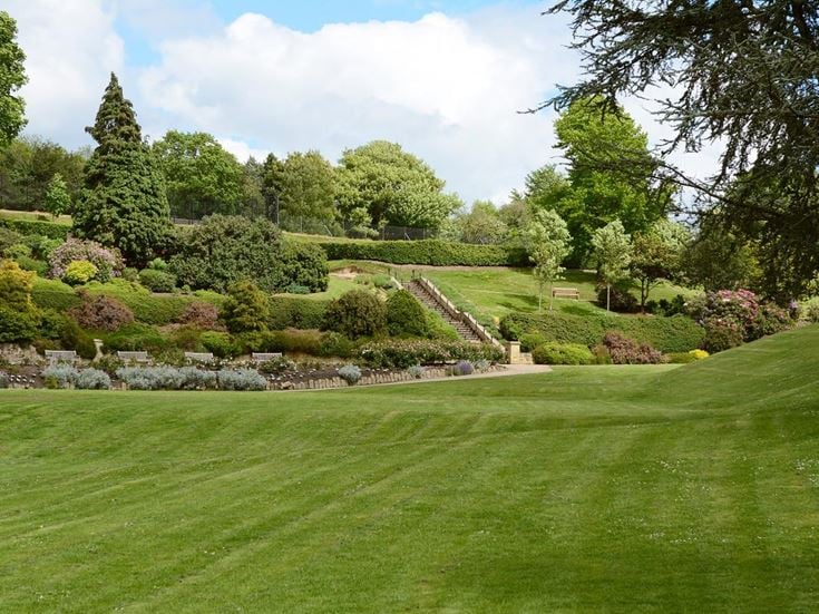 The greenery of Calverley Grounds public park in Tunbridge Wells, with landscaped plants and a walking path.