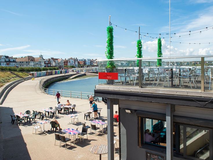 A view of the seaside promenade and a restaurant overlooking the bay.