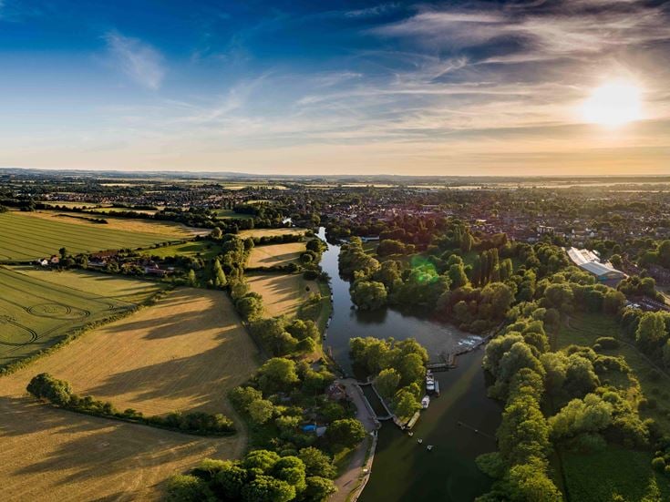 Aerial view of open fields and waterways throughout Oxfordshire on a sunny day.