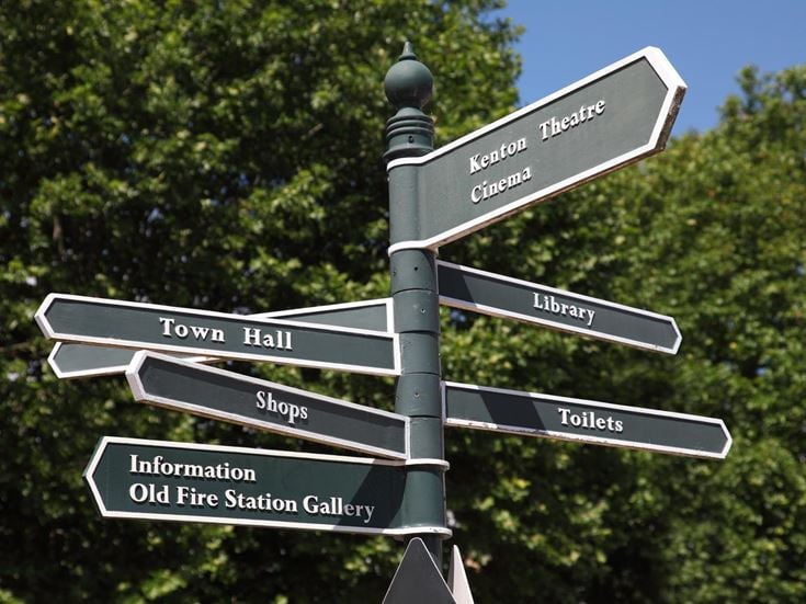 A signpost in Oxfordshire points to several amenities in the area, such as shops, theatres, and the library.