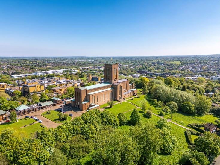 Aerial view of Guildford Cathedral overlooking Guildford town centre and the surrounding Surrey countryside.