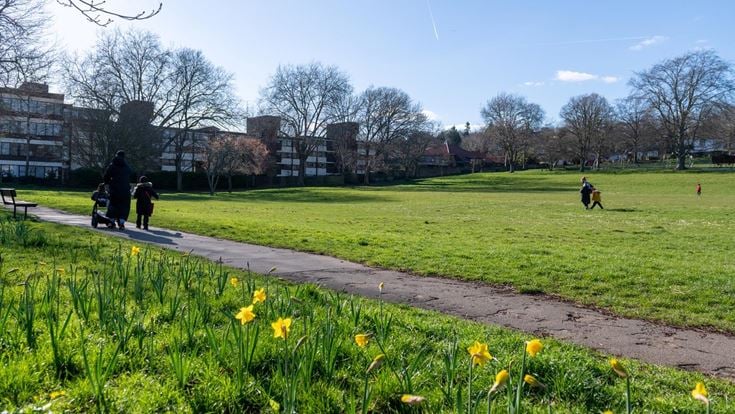 A local park close to Purley town centre with a group of people walking.