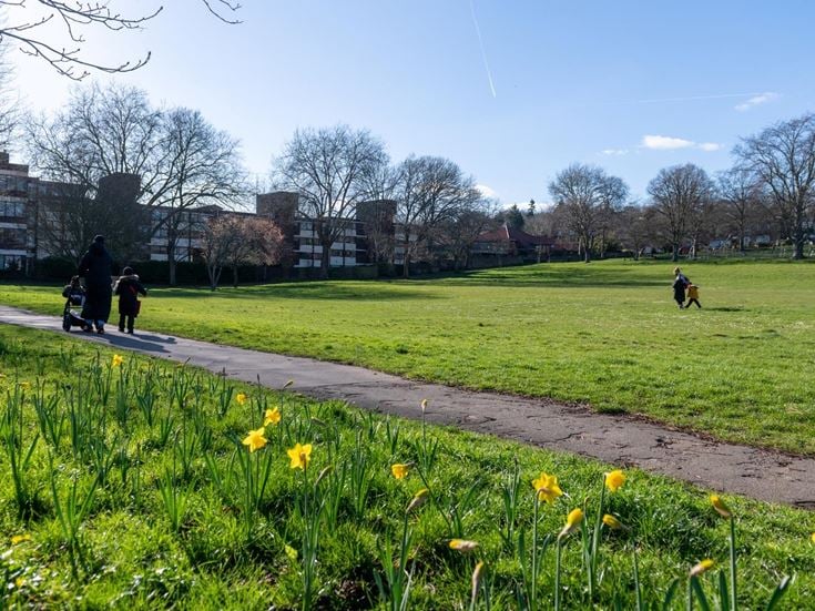 A local park close to Purley town centre with a group of people walking.