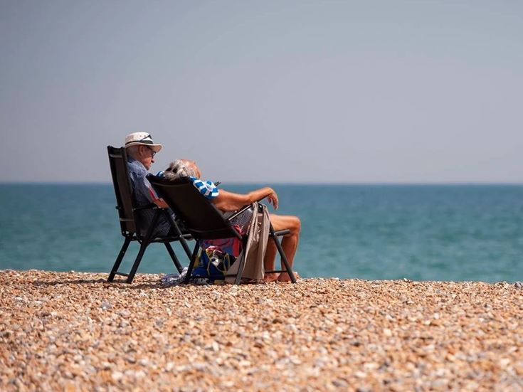 a man and woman sitting in chairs on a beach