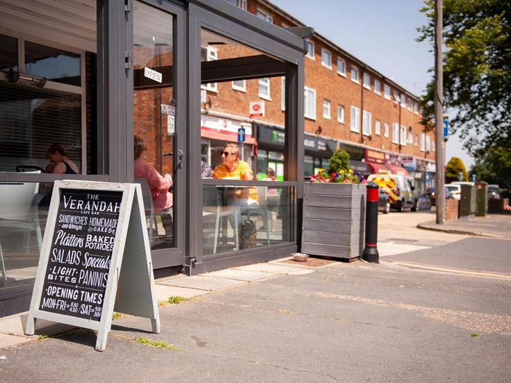 A cafe and shops on the street on a sunny day in Goring-by-Sea.