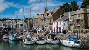 Boats docked at Padstow Harbour with old buildings in the background.