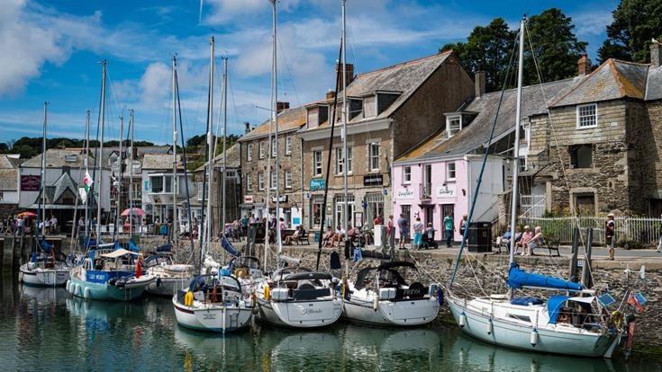 Boats docked at Padstow Harbour with old buildings in the background.