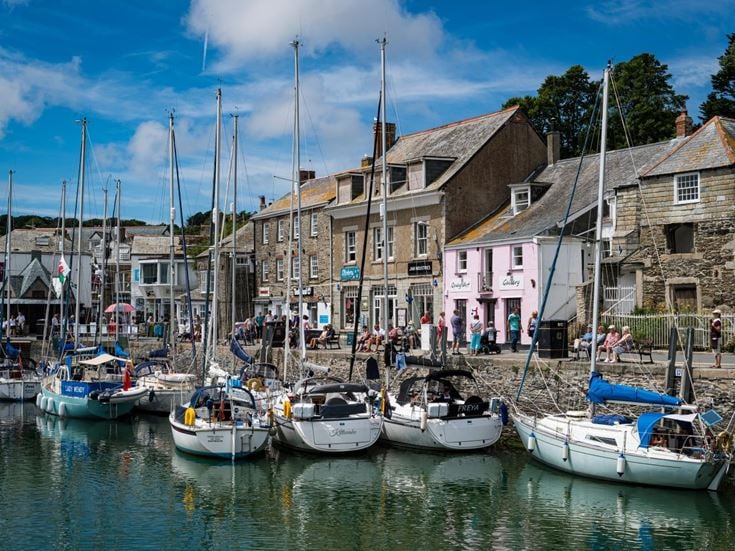 Boats docked at Padstow Harbour with old buildings in the background.