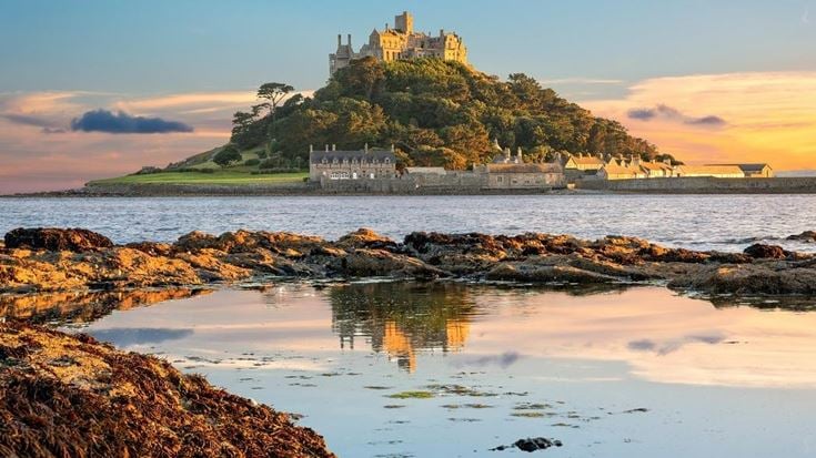 The island of St Michael’s Mount, with a historic Church and Castle surrounded by water.