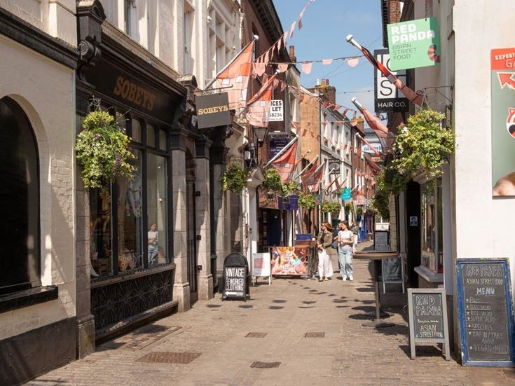 People walking down a retail street in Exeter.