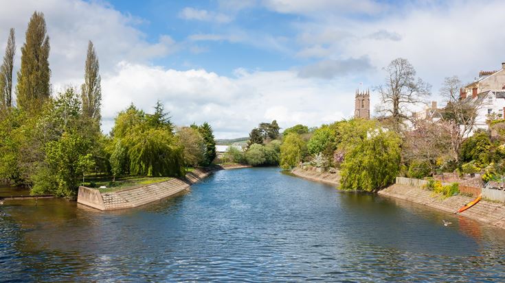 a river with trees and buildings along it