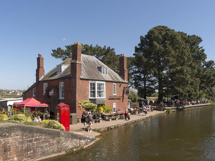 a brick building next to a river