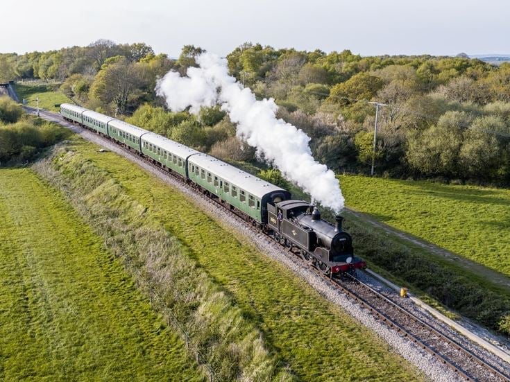 An aerial view of a steam train on the Swanage Railway near Corfe Castle.