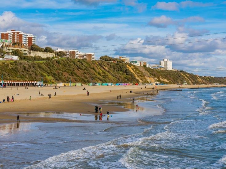 People on Bournemouth beach on a sunny day.