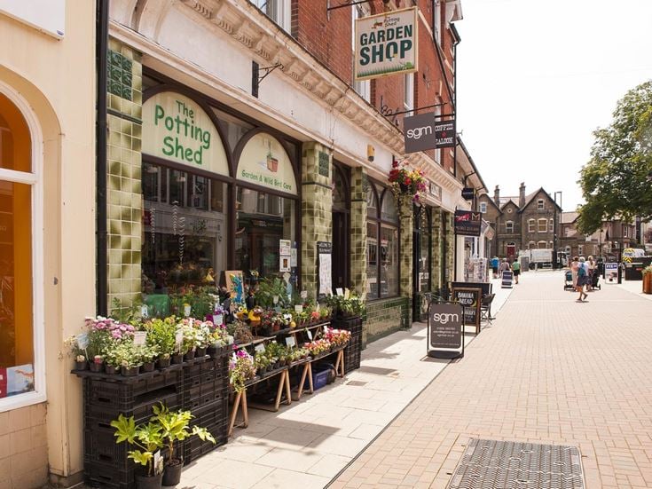 Terraced exterior of a garden shop and other stores in Dorchester town centre.