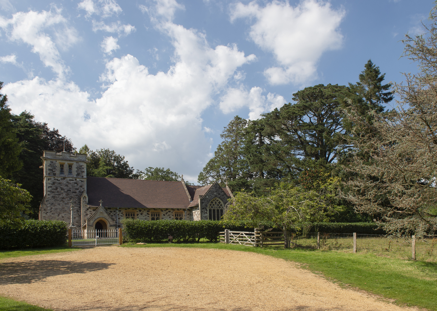 A church with a fence and trees around it close to the market town of Wimborne.