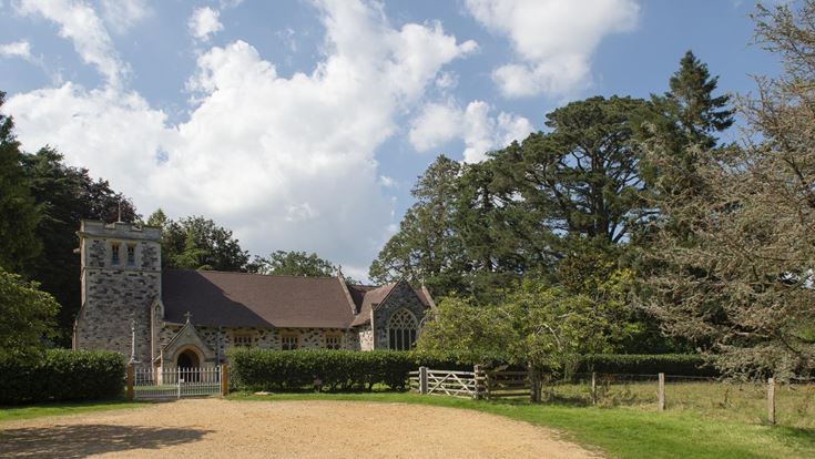 A church with a fence and trees around it close to the market town of Wimborne.