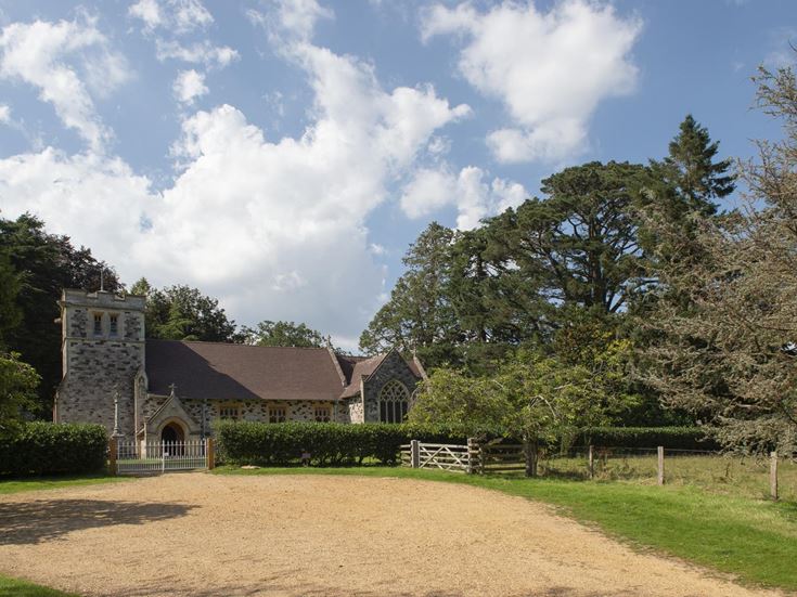 A church with a fence and trees around it close to the market town of Wimborne.