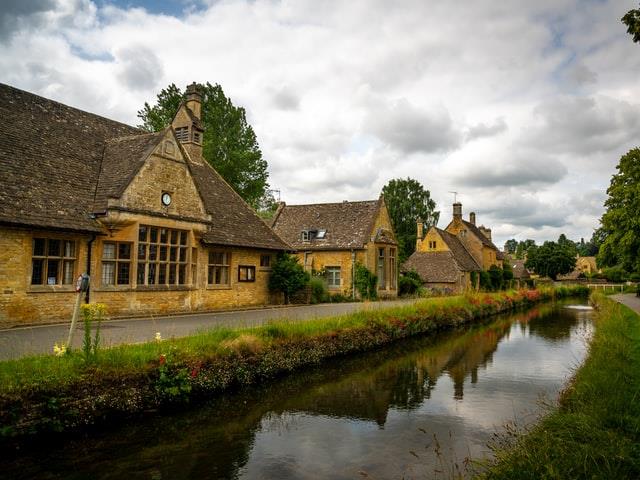 Traditional Cotswold buildings next to a waterway.