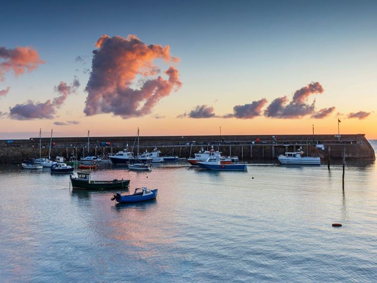 a group of boats in Minehead Harbour at sunrise