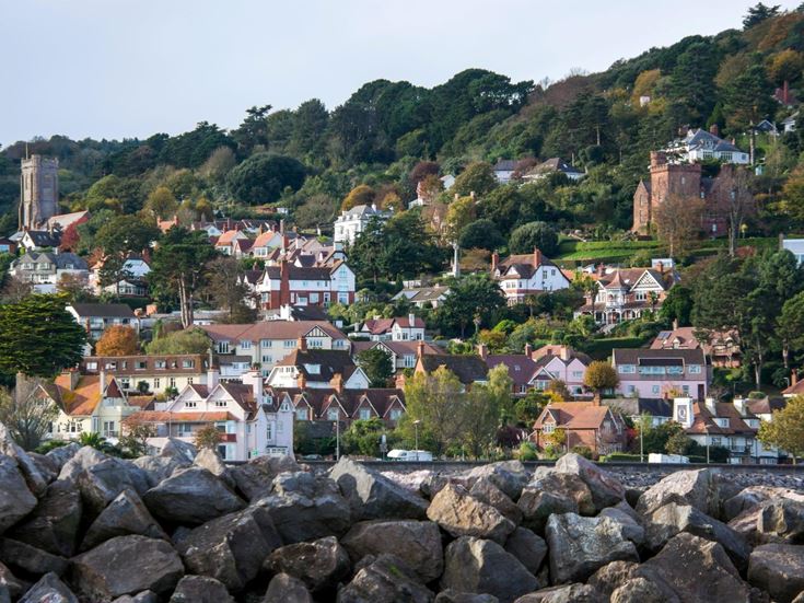 a hillside view of houses, buildings, church and trees in Minehead