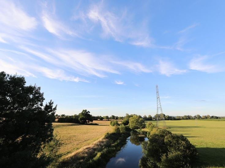 a river running through a grassy area in the countryside of Wiltshire