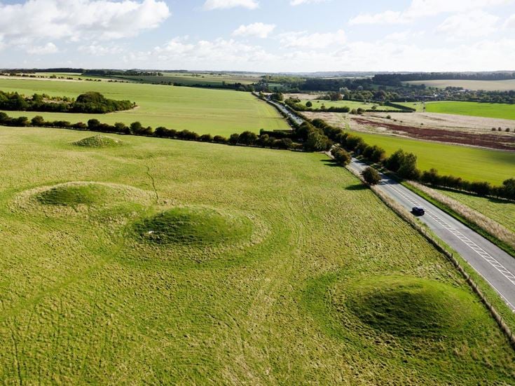 Aerial view of the prehistoric round barrow burial mounds beside A4 road on Overton Hill, Avebury