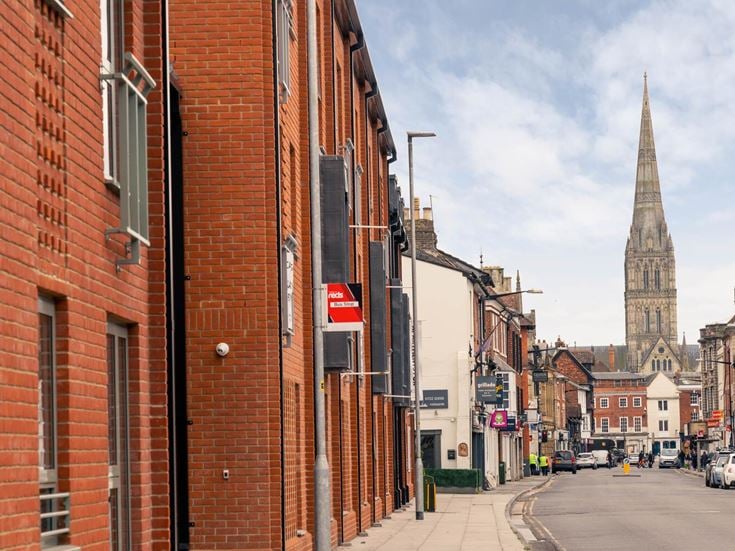 A bus stop outside of Monument Place, with the cathedral in the background.