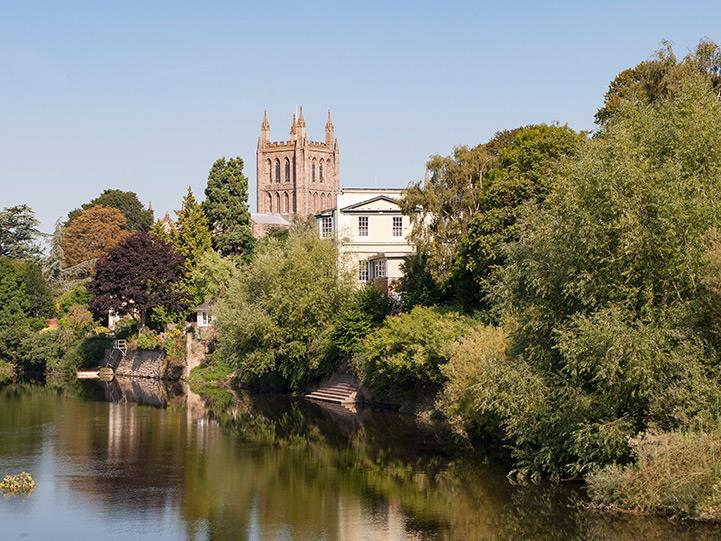 a river with trees and a castle in the background