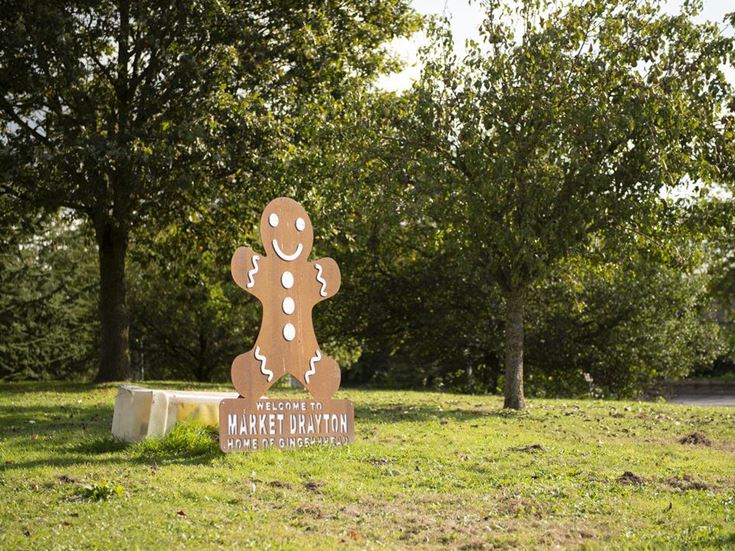 Welcome sign in the shape of gingerbread biscuit welcoming drivers to Market Drayton.