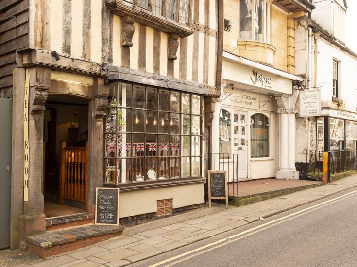 Exterior of a public house and shop on a terraced road in Market Drayton.