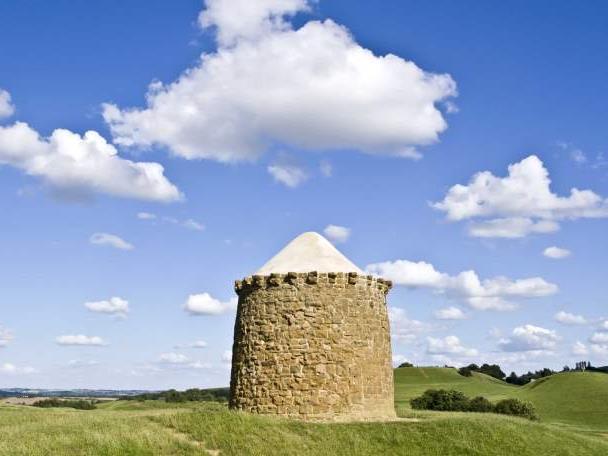 A historic tower in a field in Warwickshire, close to a walking trail.