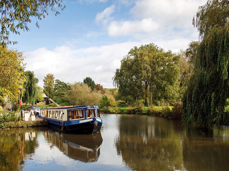 Narrow boat moored on the Avon canal awaiting tourists to cruise down the river through Stratford upon Avon