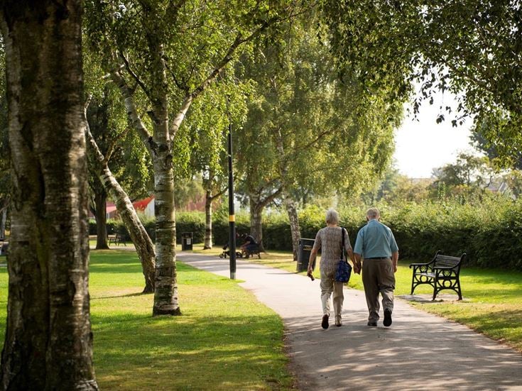 Two retired men enjoy a leisurely stroll through a park in Shirley.