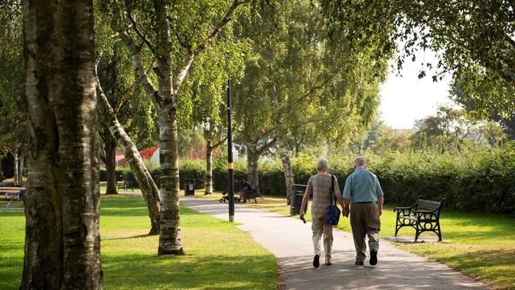 Two retired men enjoy a leisurely stroll through a park in Shirley.
