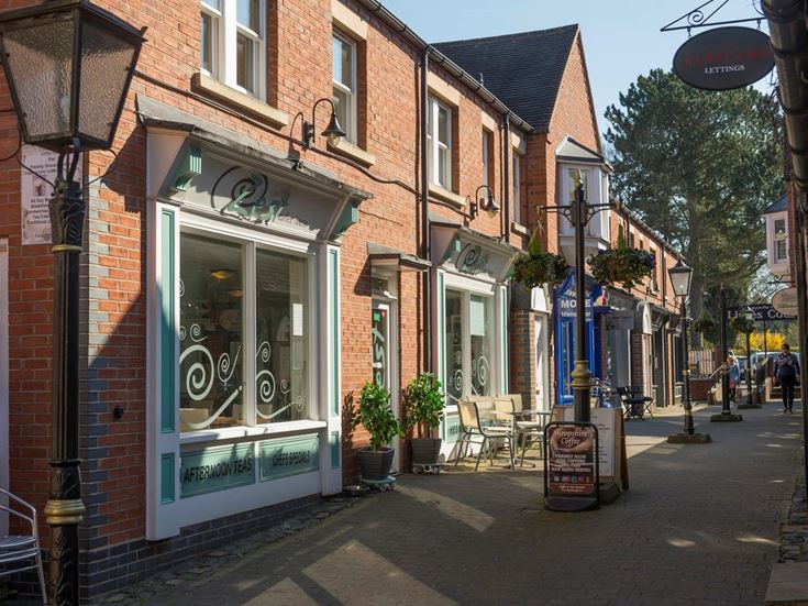 A row of shops, businesses, and restaurants line a street in Tettenhall village centre.