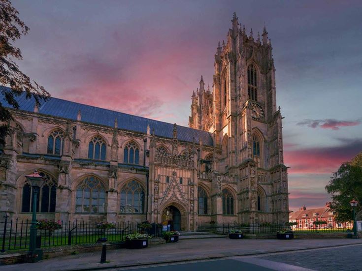 The beautiful stone exterior of Beverley Minster during a sunset.