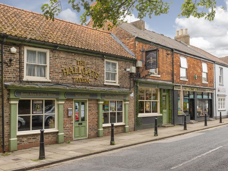 A row of pubs, shops, and local businesses on a street in Cottingham.