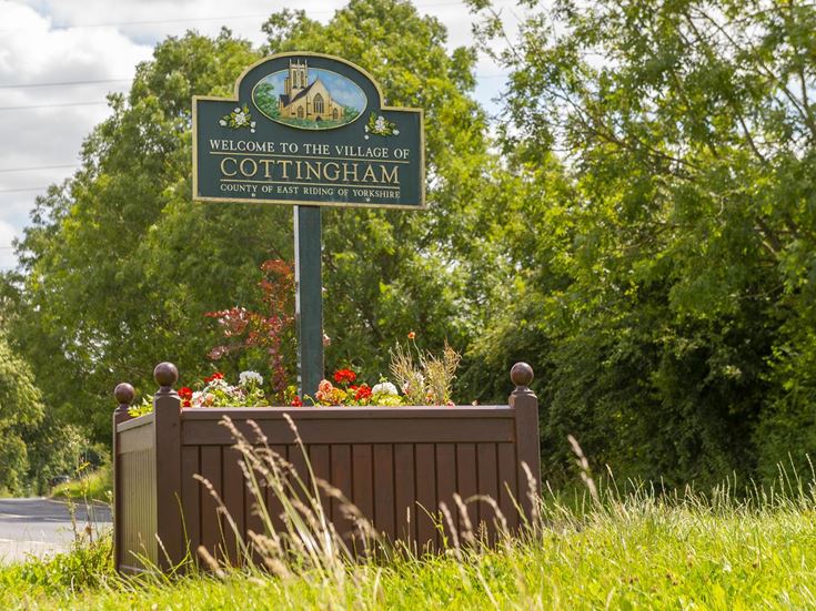 Road sign welcoming drivers to the village of Cottingham.