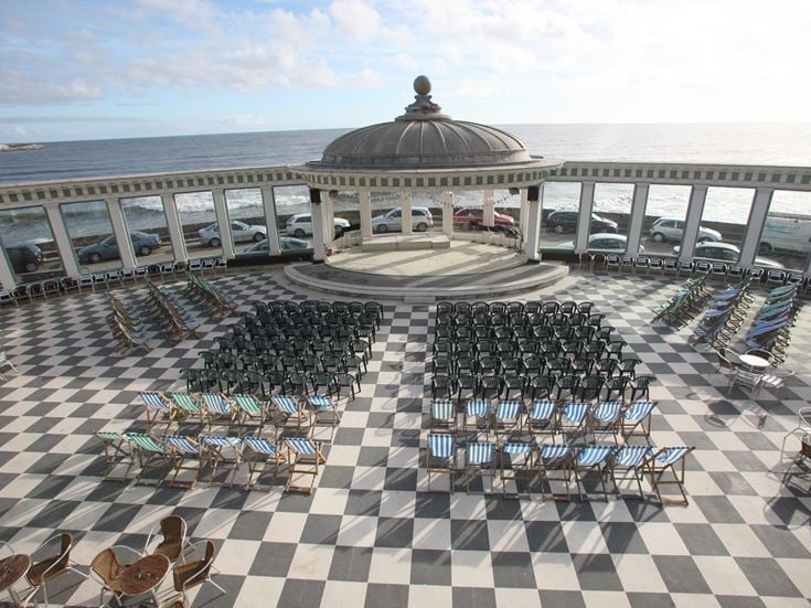 Scarborough Spa Pavillion with its chess board patio, setup with rows of chairs facing out to sea.