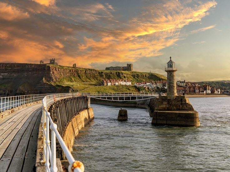 A sunset on the pier at Whitby, overlooking the lighthouse and the Abbey.