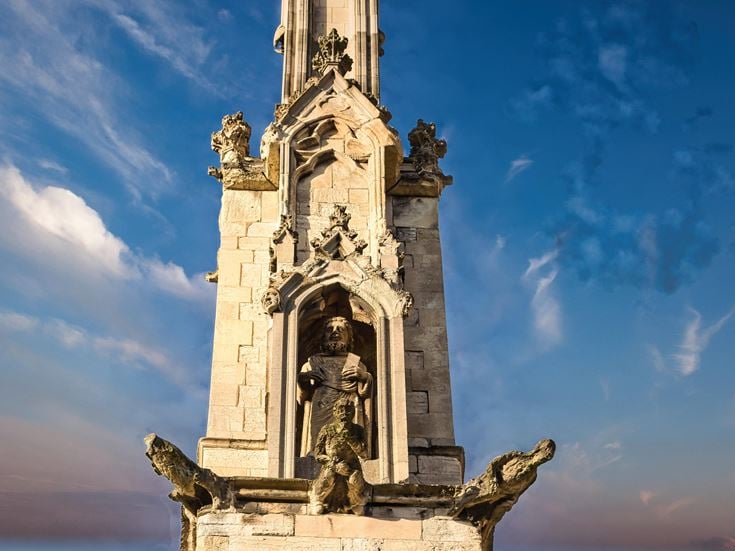 a tall stone tower with statues