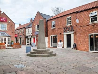 a courtyard with a fountain in front of a brick building